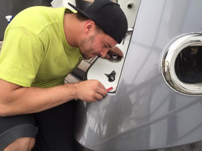 Wild Group expert team member carefully applying the detail to motor yacht Turquoise complete hull wrap and colour change