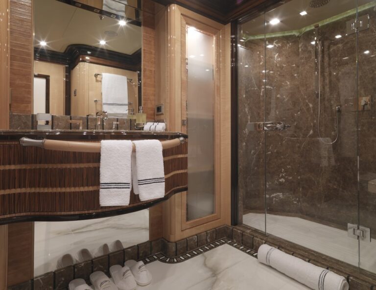 ensuite bathroom with marble walls and flooring and built-in luxury furniture