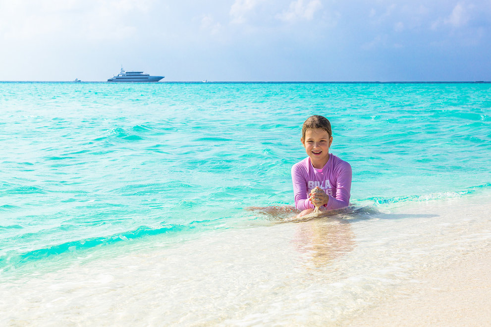 child on a beach and a yacht.jpg